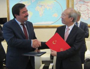 Mr. Yuichi Yamaura, Vice President of the Japan Aerospace Exploration Agency (right), and H.E. Dr. Cihan Kanlıgöz, Director General of the Aeronautics and Space Technologies, the Ministry of Transport, Maritime Affairs and Communications of the Republic of Turkey (left), exchange copies of the Cooperative Agreement in Ankara, Turkey, on 8 September 2016.